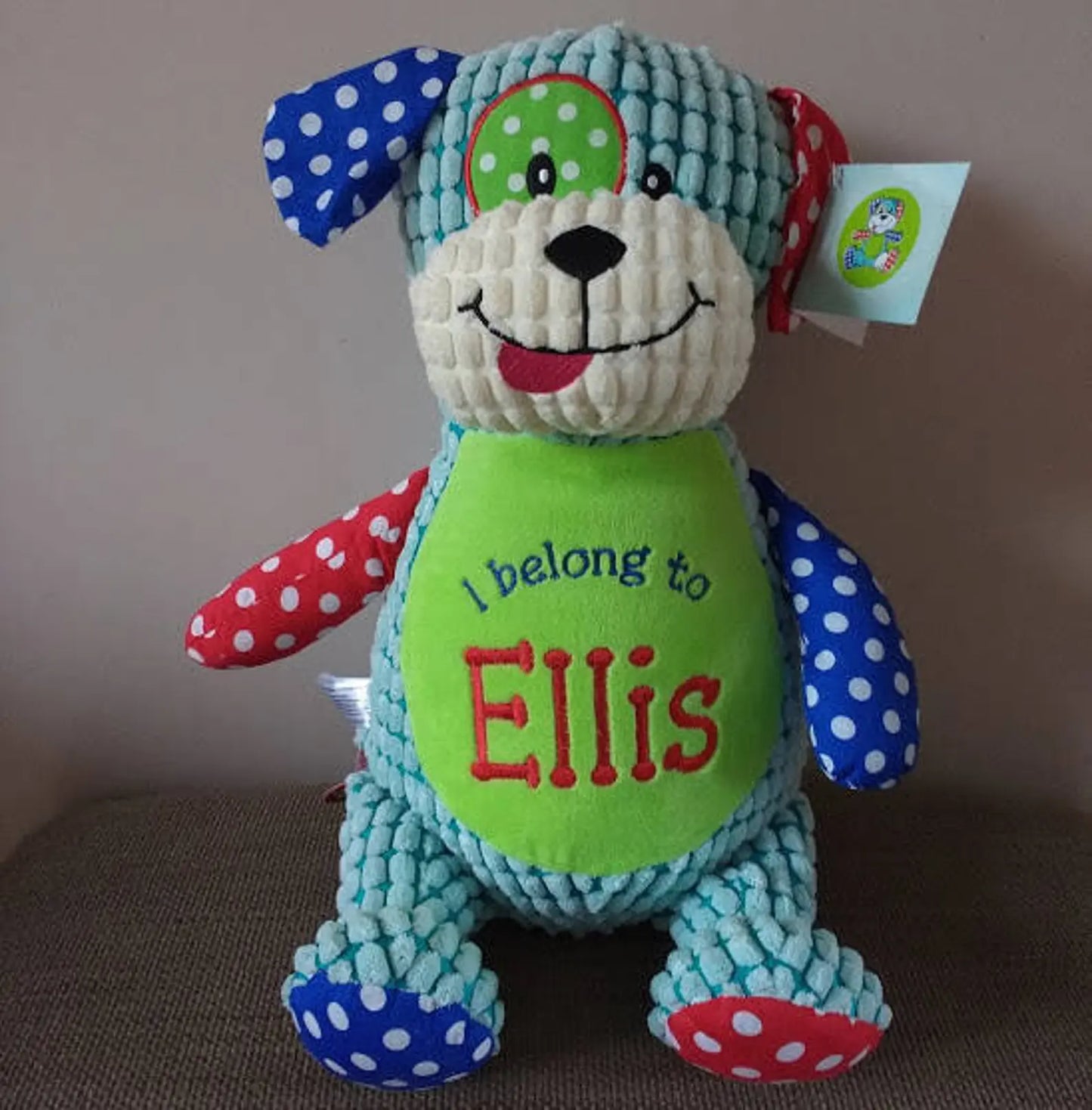 Colorful plush toy with 'I belong to Ellis' text on a plain background