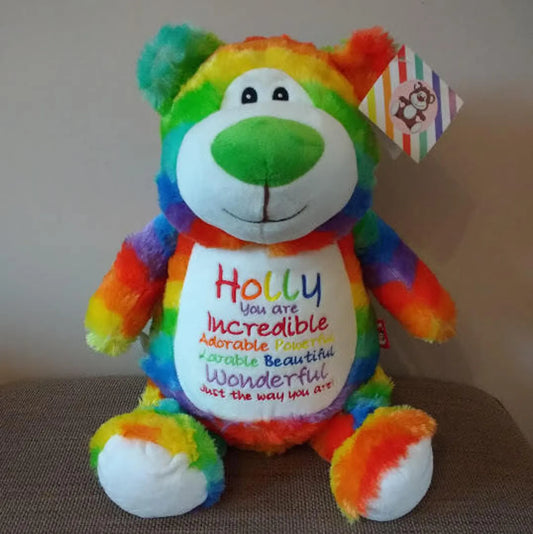 Colorful teddy bear with a message on a brown surface
