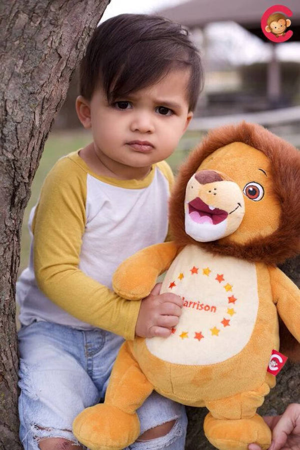 Child holding a lion-shaped plush toy outdoors