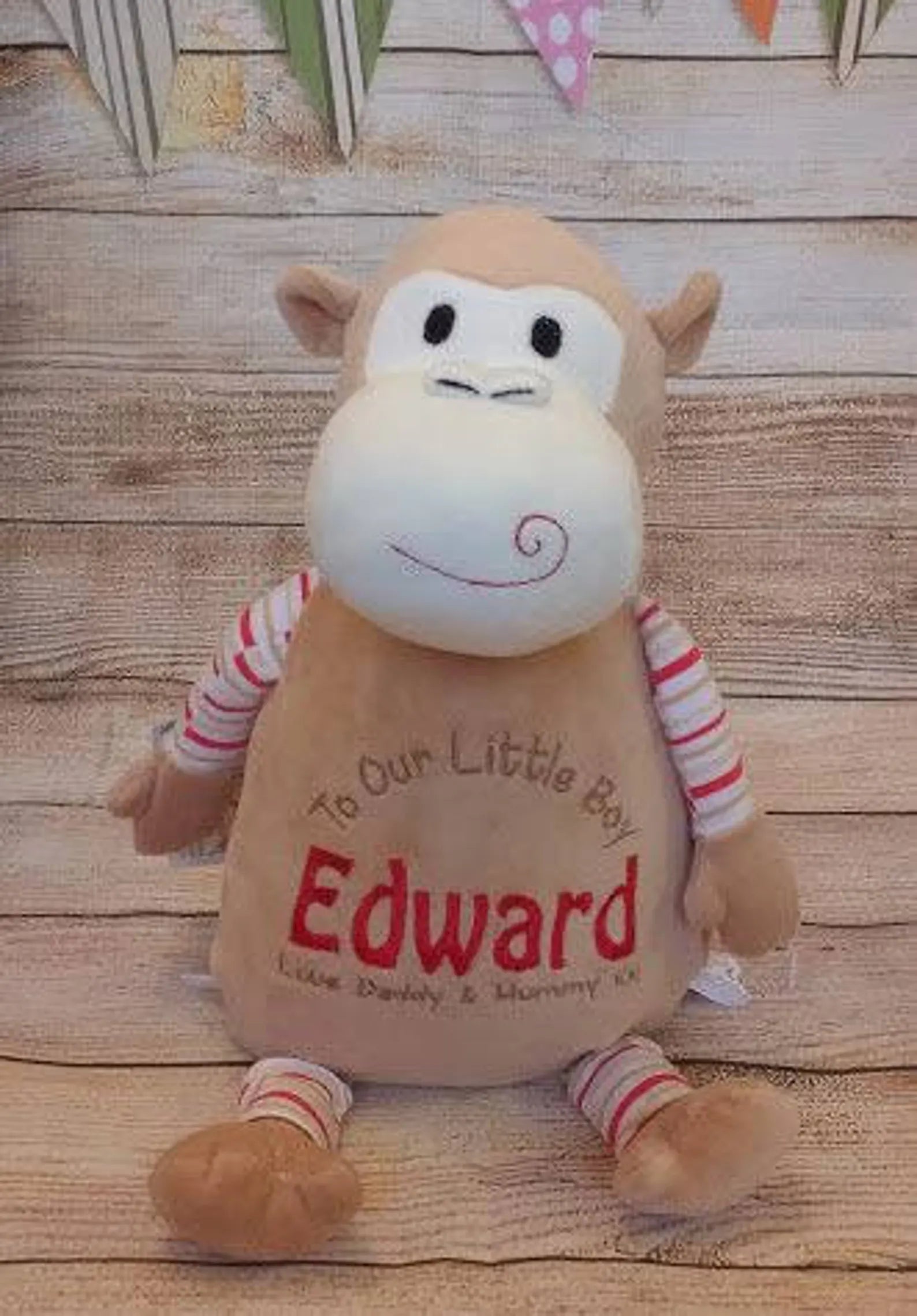 Plush monkey toy with 'Edward' on a wooden surface