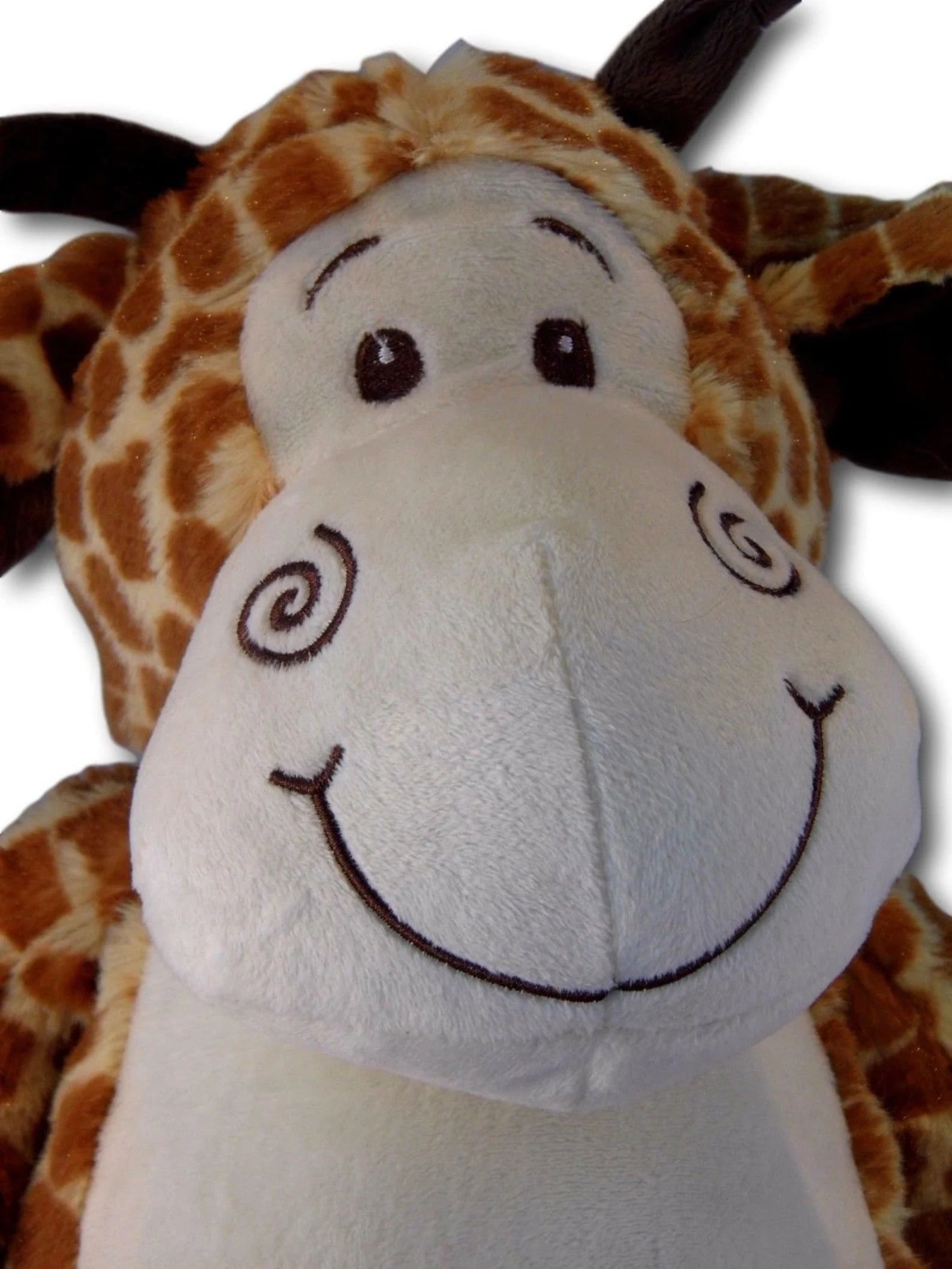 Close-up of a plush giraffe toy with a white face and brown spots.