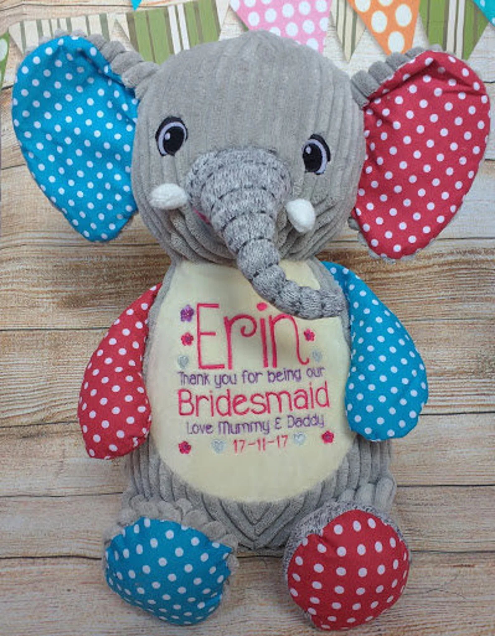Plush elephant toy with personalized message on a wooden surface