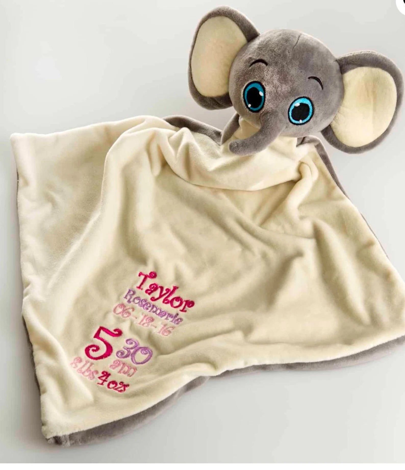 Plush elephant toy on a personalized blanket with text