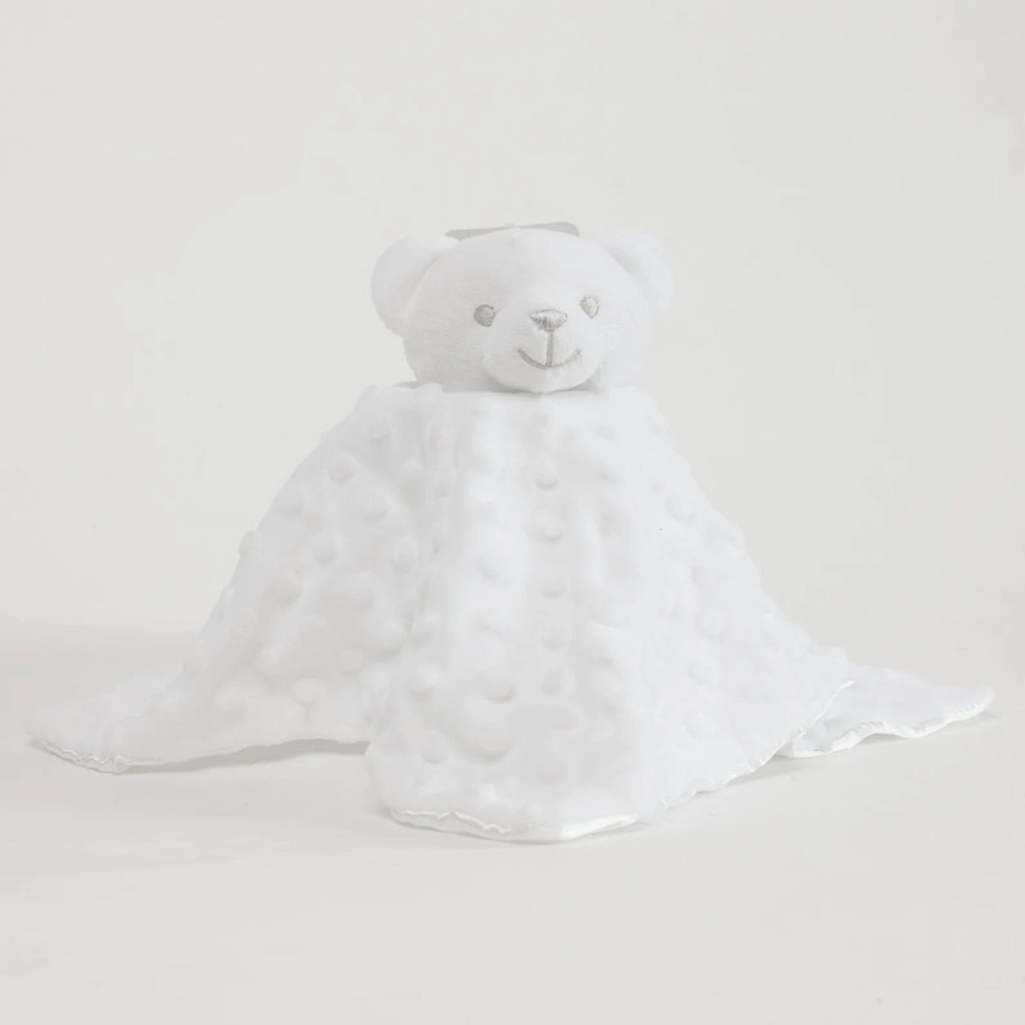 White teddy bear with a white blanket on a light gray background