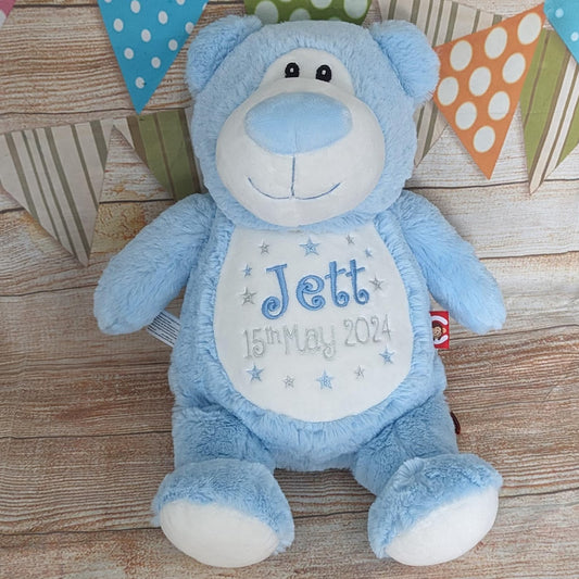 Blue teddy bear with personalized text on a wooden surface