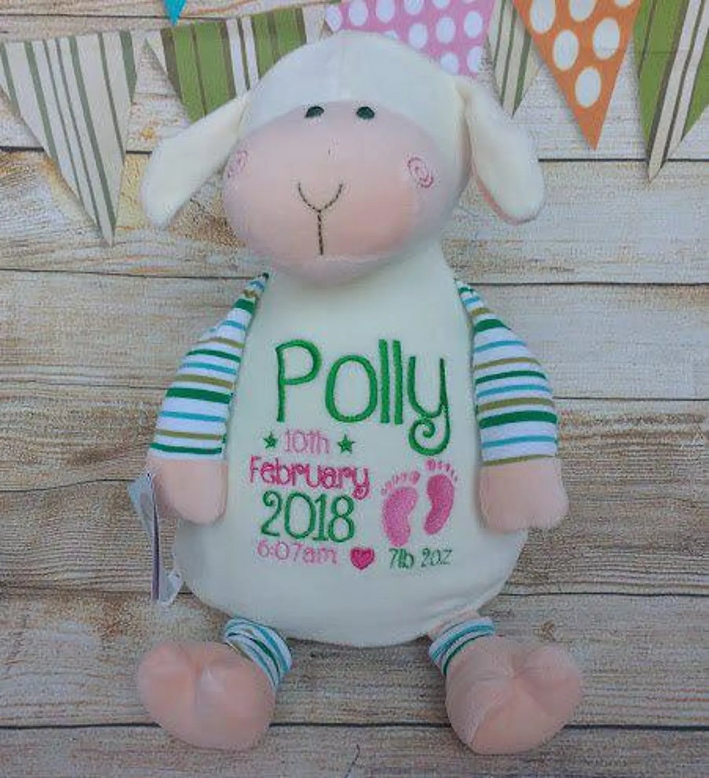 Plush lamb toy with personalized text on a wooden surface