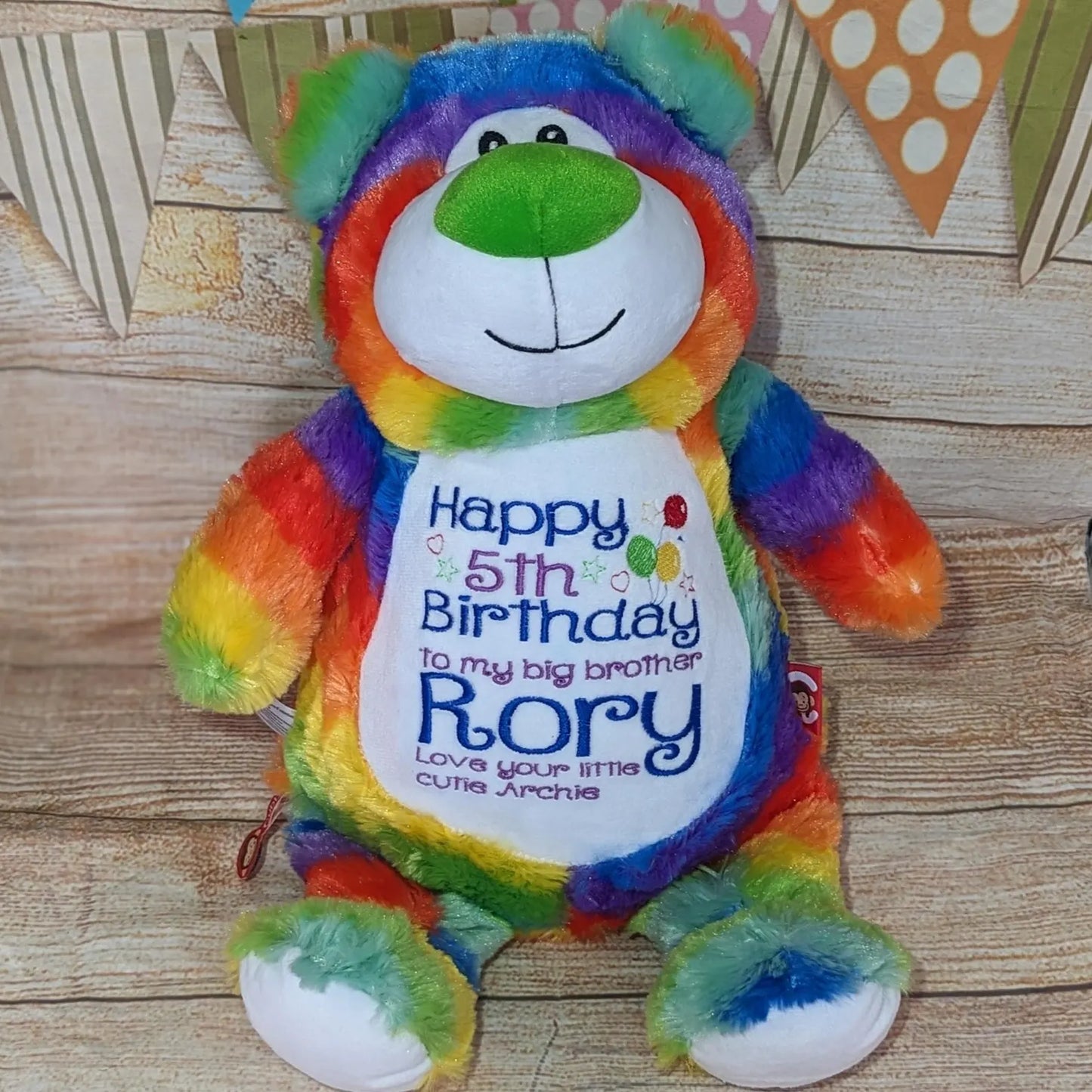 Colorful teddy bear with a birthday message on a wooden surface