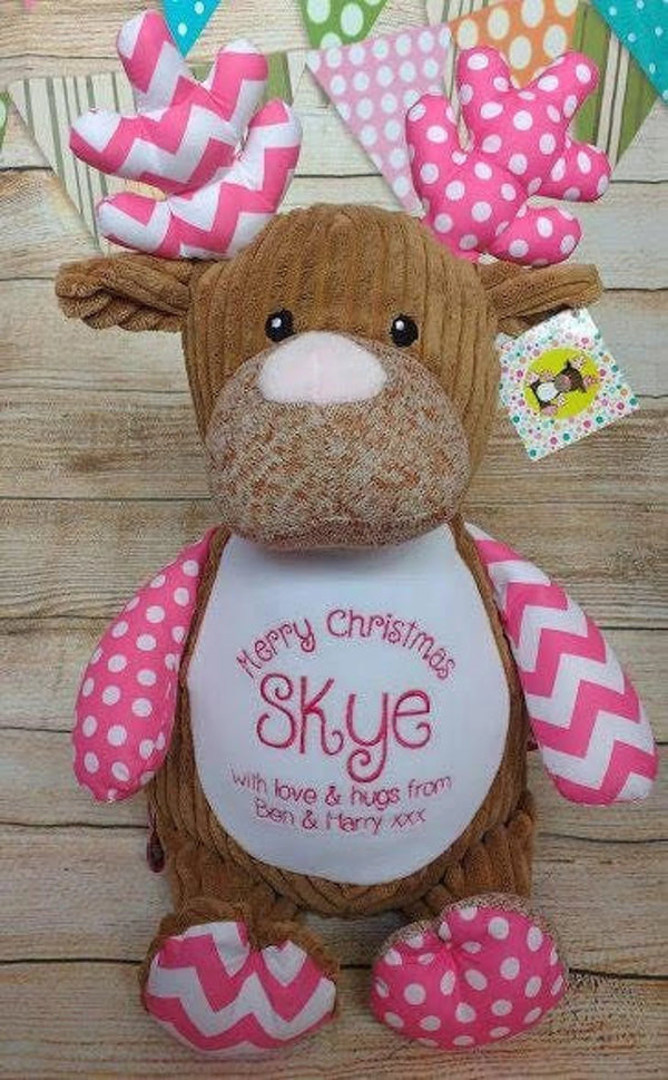 Plush reindeer toy with pink and white decorations on a white background