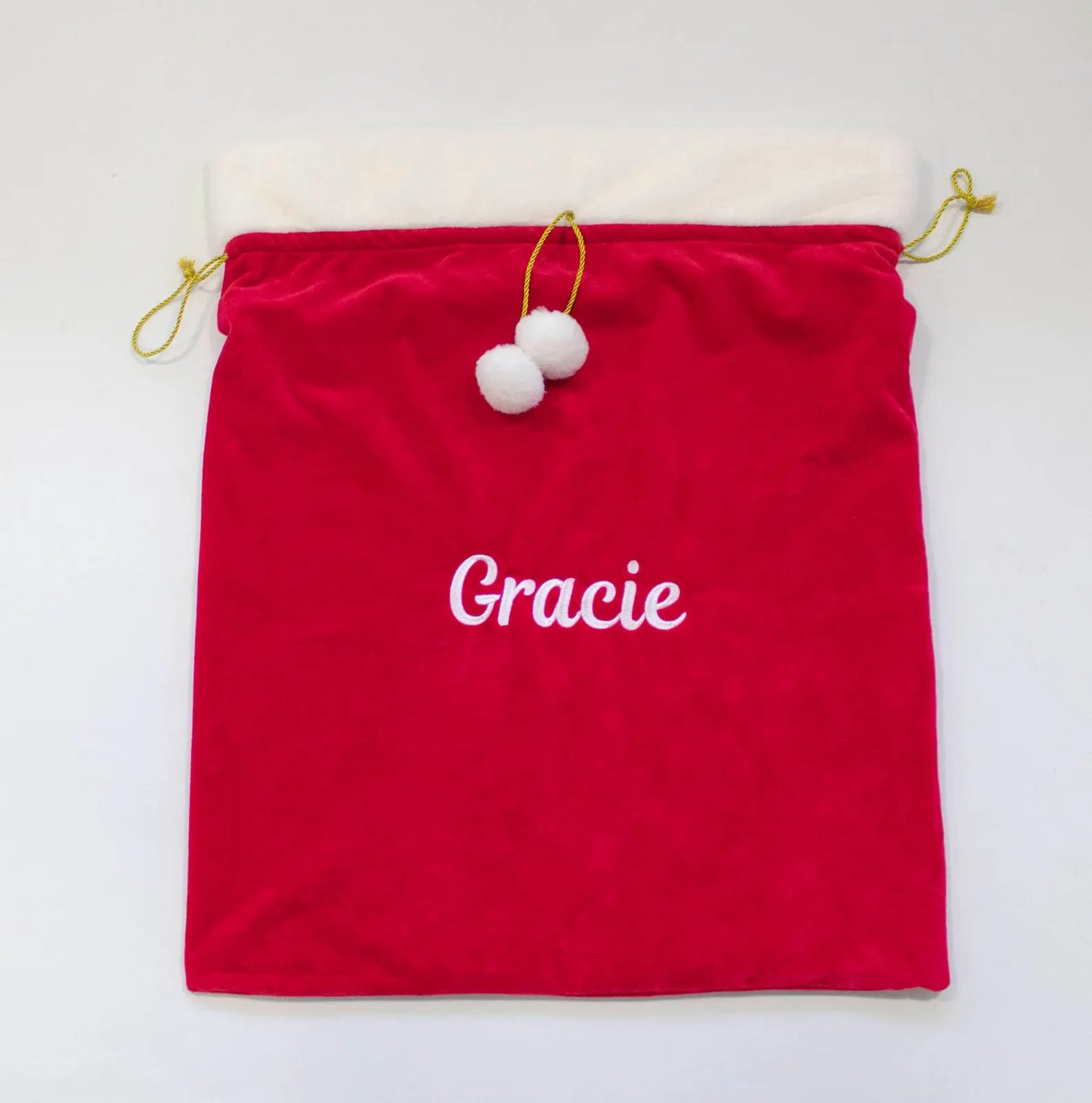 Red drawstring bag with 'Gracie' embroidered on it, on a white background