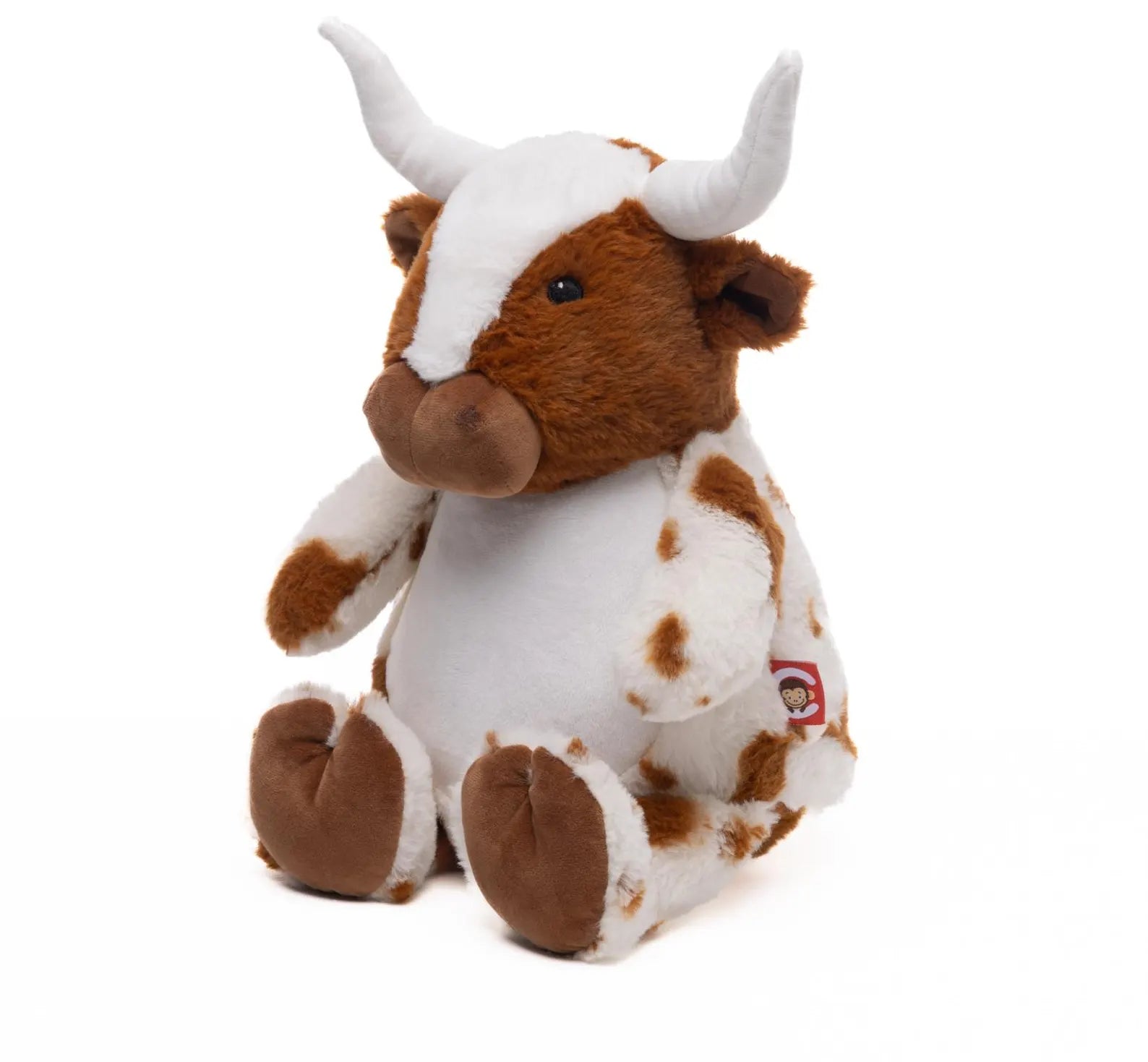 Plush toy bull with brown and white color scheme on a white background