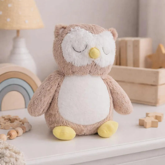 Plush owl toy on a shelf with wooden blocks and a lamp in the background