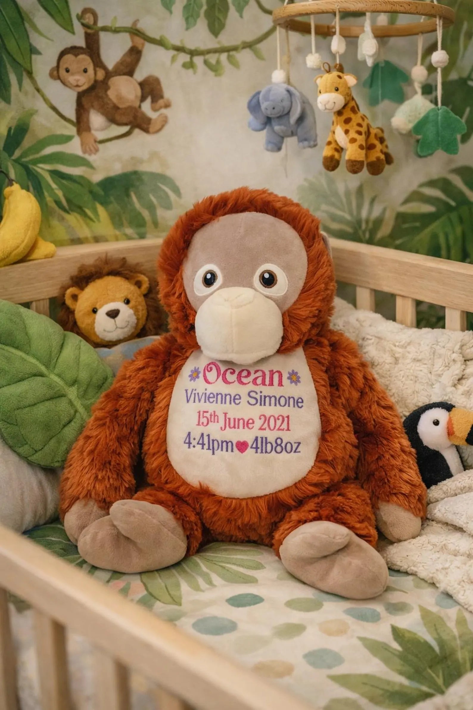 Stuffed monkey toy with personalized details in a crib with jungle-themed decorations