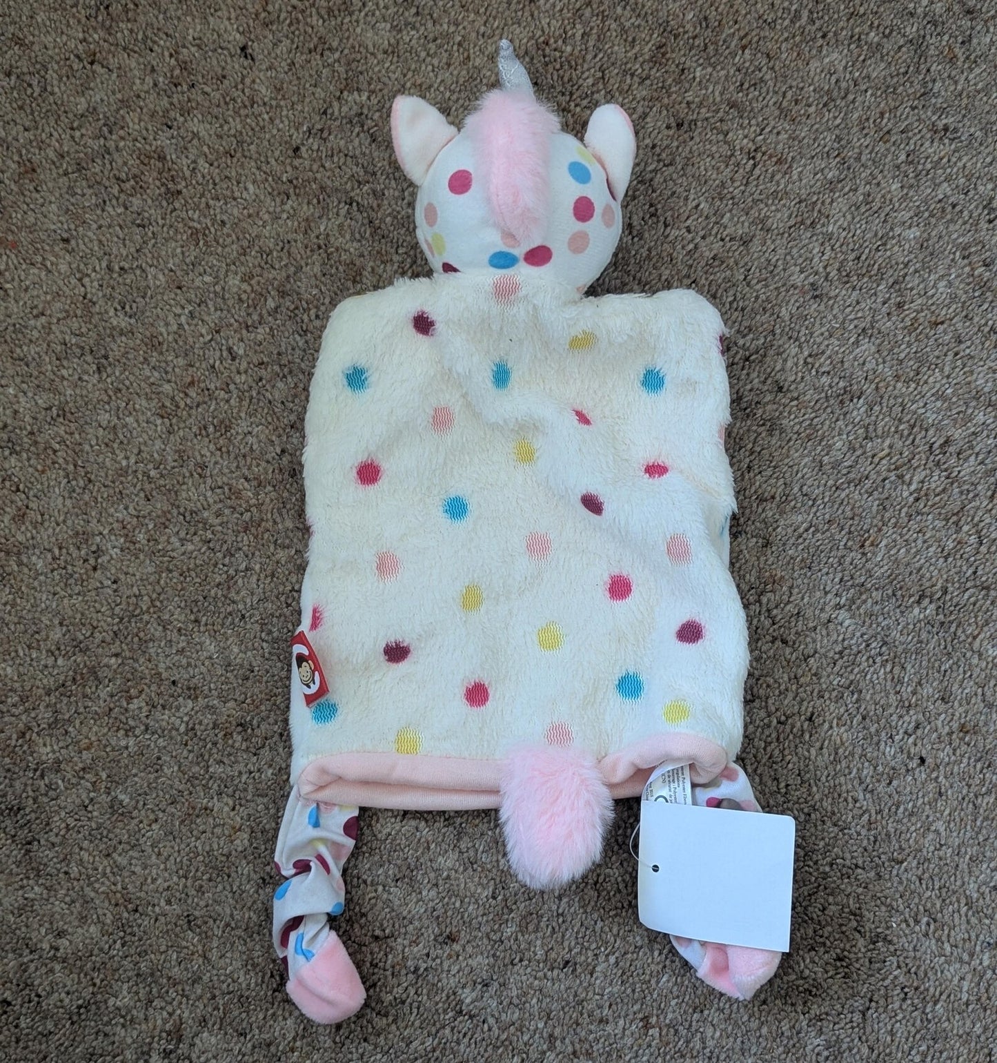 Plush toy with polka dot pattern on a beige carpet