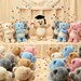 Three small plush toys on a wooden surface with a blurred background